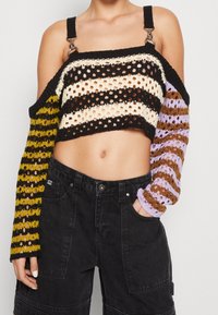 Top corto all'uncinetto con strisce multicolori in nero, crema, senape, marrone e lavanda. Design a tessitura aperta con spalline regolabili.