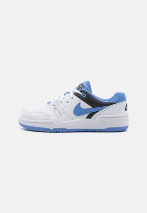 Witte lage sneaker met lichtblauwe accenten, een zwart detail bij de hiel en een lichtblauw Nike swoosh-logo aan de zijkant.