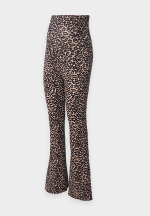 Leggings mit Leopardenmuster, weit geschnitten und mit hohem Bund. Hergestellt aus dehnbarem Stoff, mit einem beigefarbenen Grundton und schwarzen Flecken.