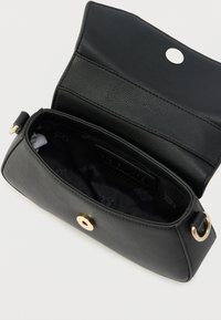 Geantă de mână din piele neagră cu o suprafață texturată, prevăzută cu o închidere aurie cu capse și un interior spațios, căptușit cu material textil.