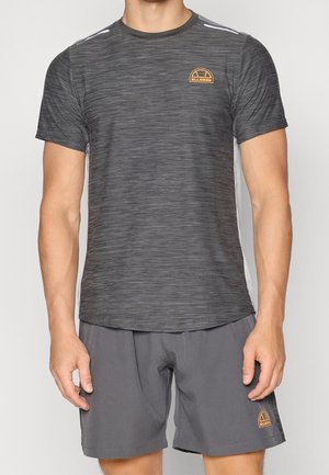 Homme portant un t-shirt de sport à manches courtes gris foncé et un short assorti avec petits logos Ellesse orange sur la poitrine et la jambe.