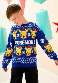Niebieski sweter robiony na drutach z wieloma wzorami Pikachu w czapkach Świętego Mikołaja, z białymi akcentami i płatkami śniegu. Idealny na okazje świąteczne.