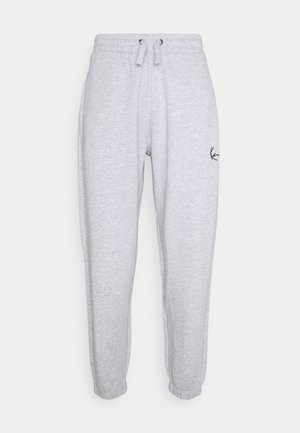 Pantalon de survêtement gris clair en tissu doux, avec une taille élastique et un cordon de serrage ainsi qu'un petit logo noir sur la cuisse gauche.