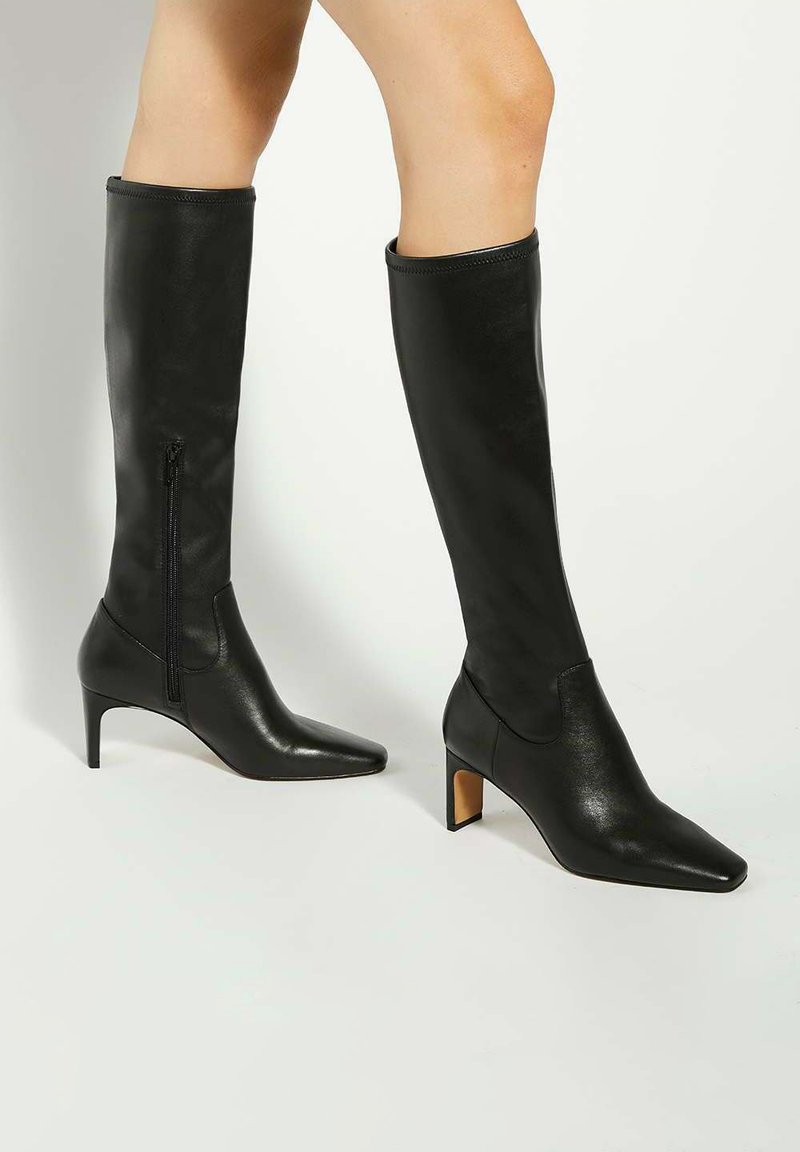 Black knee-high boots with a pointed toe and curved heel. Made of smooth leather, featuring a side zipper for easy wear.