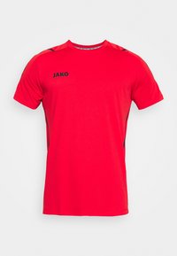Camiseta atlética de manga corta roja con el logo negro "JAKO" en el lado izquierdo del pecho y con detalles negros en los hombros y los lados.