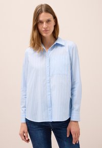 Camicia button-up azzurro chiaro con righe verticali in diverse tonalità, taschino a sinistra sul petto e maniche lunghe con polsini abbottonati.