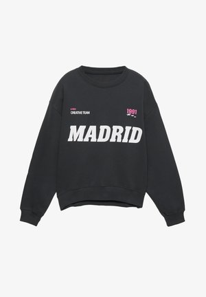 Czarna bluza z okrągłym dekoltem, z wyraźnym białym napisem "MADRYT", różowymi akcentami i graficznymi detalami. Miękka tkanina, luźny krój.