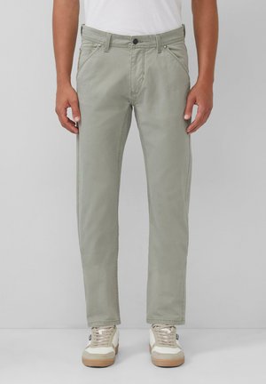 Hellgrüne Baumwollhose mit geradem Schnitt, ausgestattet mit einem Knopf- und Reißverschluss, seitlichen Taschen und einer glatten Textur. Kombiniert mit weißen Sneakers.