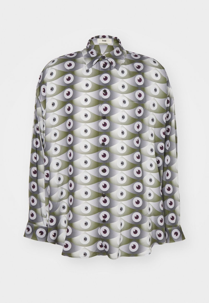 Langærmet skjorte lavet af letvægtsstof, med et gentaget mønster af øjne i grønne og grå nuancer med sorte accenter og knapper.