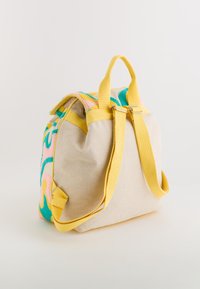 Sac à dos avec un dessus en tissu texturé et coloré en rose, bleu et jaune. Corps en toile beige et bretelles jaunes avec des quincailleries en métal.