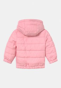 Giacca puffer rosa con cappuccio, caratterizzata da una textura trapuntata, polsini elasticizzati e una lunghezza corta. Materiale morbido senza hardware visibile.