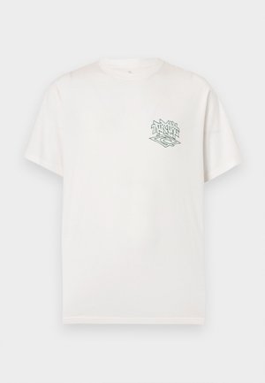 T-shirt blanc à manches courtes et col rond avec un petit motif abstrait noir et vert sur la poitrine gauche.