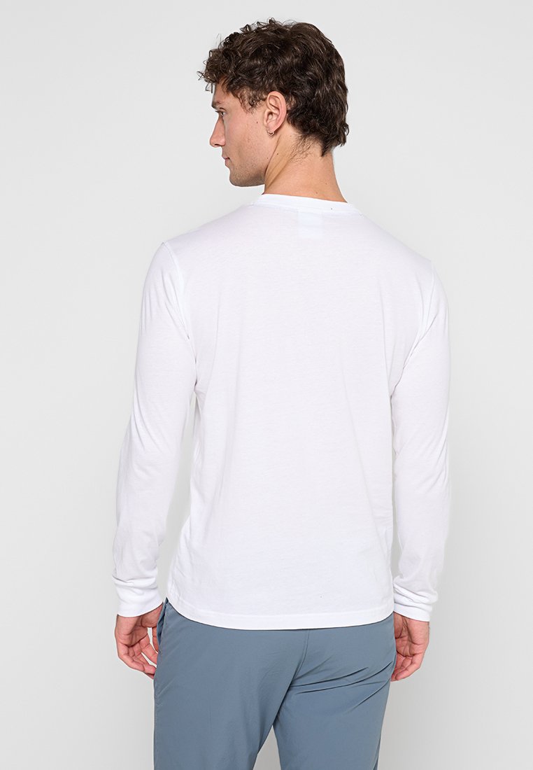 Camiseta de manga larga blanca con cuello redondo, hecha de tejido ligero, con una textura suave y un diseño sencillo.