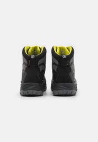 Czarne wodoodporne buty trekkingowe z fakturowanym wzorem, kontrastowym żółtym wykończeniem i solidnymi gumowymi podeszwami zapewniającymi przyczepność.