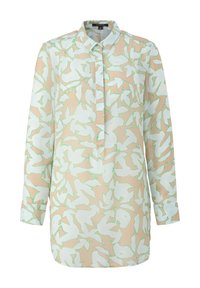 Blusa a maniche lunghe in tessuto leggero e trasparente, con sfondo beige e con motivi astratti di foglie bianche e verdi, e chiusura con bottoni.