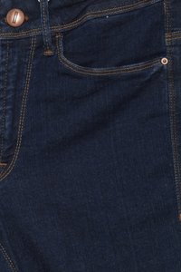 Jeans de denim azul oscuro con botón de cobre y costuras. Incluye bolsillo frontal y textura suave. Diseño clásico de cinco bolsillos.