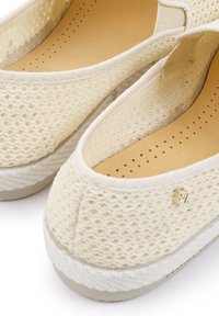 Lichte, crèmekleurige instappers met een geweven mesh bovenzijde, beige binnenzool en textuur witte rubberen zool. Discrete merkdetails zijn inbegrepen.