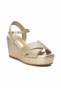 Sandali wedge intrecciati in oro con cinturini incrociati, cinturino alla caviglia regolabile e piattaforma in stile juta testurizzata. Finitura metallizzata liscia.
