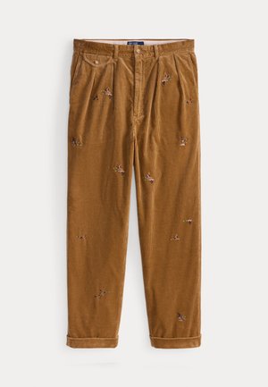 Corduroy trousers in warm brown with colorful floral embroidery; features stitched pleats and rolled cuffs for a relaxed fit.