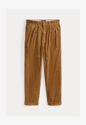 Corduroy trousers in warm brown with colorful floral embroidery; features stitched pleats and rolled cuffs for a relaxed fit.