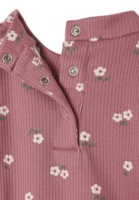 Ribbeliger, rosa Stoff mit weißem Blumenmuster. Hat einen Knopfkragen mit silbernen Druckknöpfen und einem kleinen Taschen-Detail.