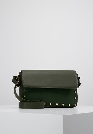 Bolso cruzado rectangular de color verde oscuro con cierre de solapa, correa ajustable y detalles de tachuelas en tono dorado en el borde inferior delantero.