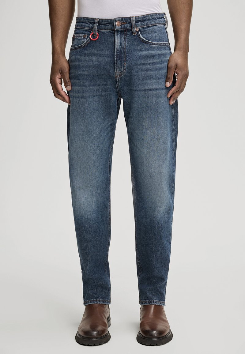 Granatowe dżinsy o prostym kroju, z czerwoną pętelką, klasycznym pięciokomorowym designem i delikatnym wybladzeniem na nogawkach.