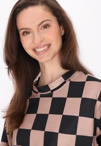 Camiseta a rayas en negro y rosa con cuello redondo. Tela suave y lisa con bloques de color atrevidos y contrastantes. Adecuada para el uso diario.