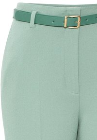 Mięta zielone spodnie z wysokim stanem wykonane z teksturowanej tkaniny, z pasującym paskiem ze złotą klamrą i kieszeniami po bokach.