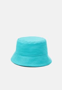 Turkusowa czapka z bawełny o miękkiej teksturze. Charakteryzuje się szerokim daszkiem o opadającym kształcie oraz haftowanymi detalami wokół korony.