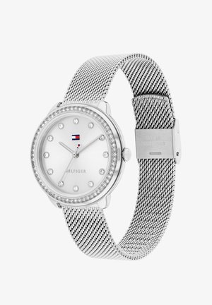 Silver mesh strap watch with round case, crystal accents, white dial, and logo detail. Features minimalist hour markers and smooth finish.
