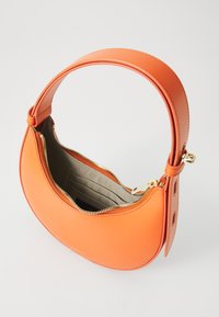 Oranje leren handtas met een ronde vorm, ritssluiting en een brede schouderband. Het interieur heeft een beige voering en meerdere kaartsleuven.
