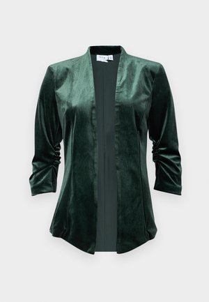 Velvet groene jas met een sjawl kraag, open voorkant en driekwart mouwen. De stof heeft een zachte, gladde textuur en een subtiele glans.
