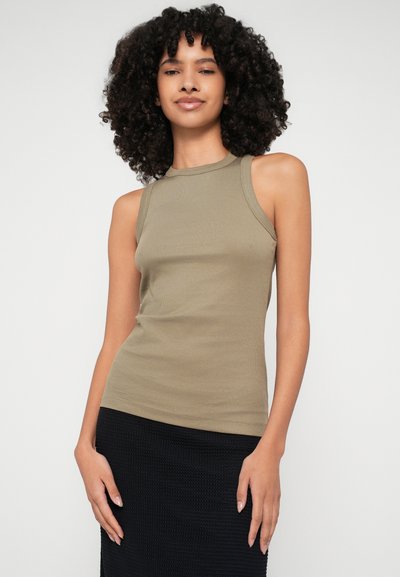 Top verde măsliniu cu nervuri, cu guler rotund și design asimetric al umărului, asociat cu o fustă neagră texturată.