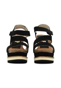 Sandali platform in suede nero con molteplici cinturini incrociati, soletta in sughero e suola a contrasto beige e bianca.