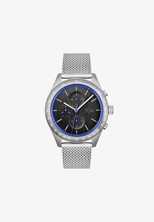 Reloj con correa de malla plateada, esfera negra texturizada, acentos en azul, tres subesferas y caja de acero inoxidable. Logo de LACOSTE en la esfera.