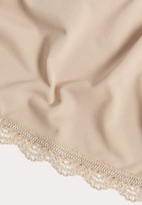 Beżowa tkanina o teksturowanym, prążkowanym wzorze, z delikatną koronkową lamówką wzdłuż jednego brzegu, podkreślająca misternie szczegóły.