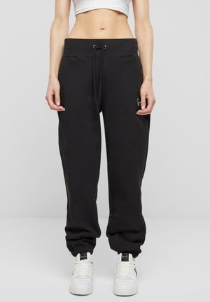 Black sweatpants made from cotton blend, featuring an elasticized waistband with drawstring, ribbed cuffs, and side pockets.