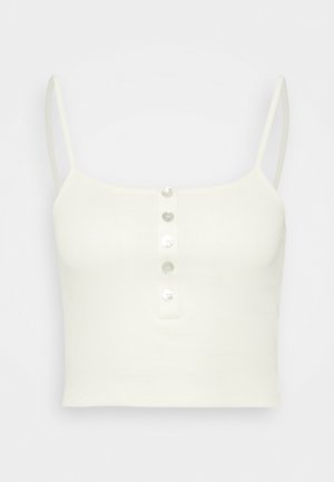 Hvid ribbet cropped top med tynde skulderstropper og fem små runde knapper ned langs midten foran.