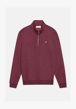 Burgundi színű, negyed zippes pulóver, puha anyagból készült, bordás gallérral és mandzsettával, valamint egy kis sárga logóval a mellrészen.