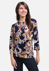 Navy blue long-sleeve shirt featuring a vibrant floral pattern in orange, green, and blue. Soft, lightweight fabric with a relaxed fit.