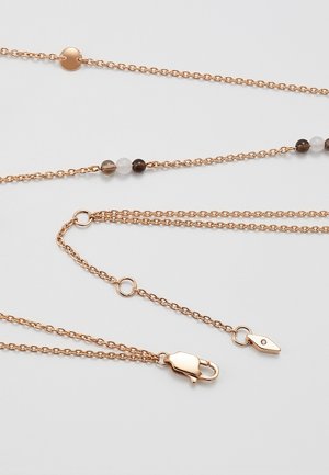 Trois fines chaînes en or rose avec un fermoir, de petites perles rondes et des maillons circulaires et en forme d'étiquette sur fond blanc.