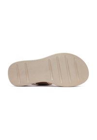 Suola in gomma beige con superficie texturizzata. Presenta scanalature orizzontali per migliorare la presa e una forma arrotondata e liscia. Design piatto per il comfort.