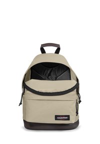 Bežový látkový batoh zaobleného tvaru, s černým zipovým uzavíráním a texturovaným tmavě hnědým dnem. Obsahuje hnědou akcentovou rukojeť nahoře.