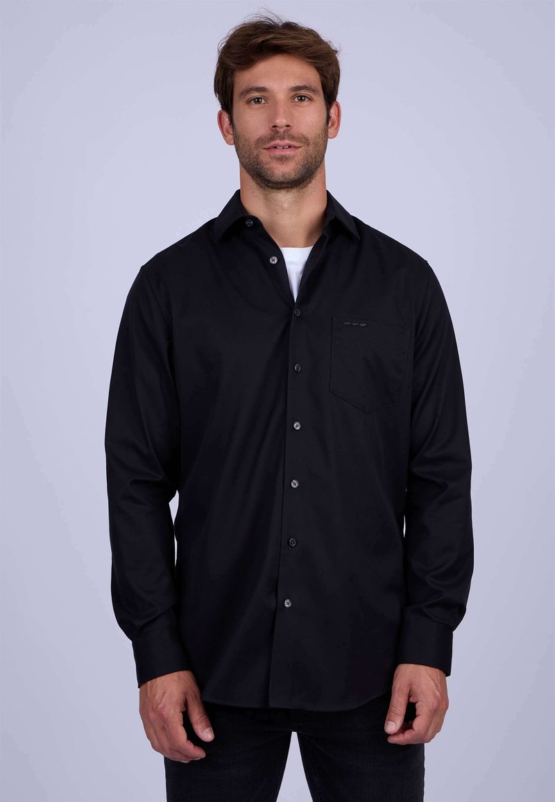 Chemise noire à manches longues avec un design à boutons, poche poitrine simple et tissu texturé. Caractérisée par des boutons gris et une coupe régulière.