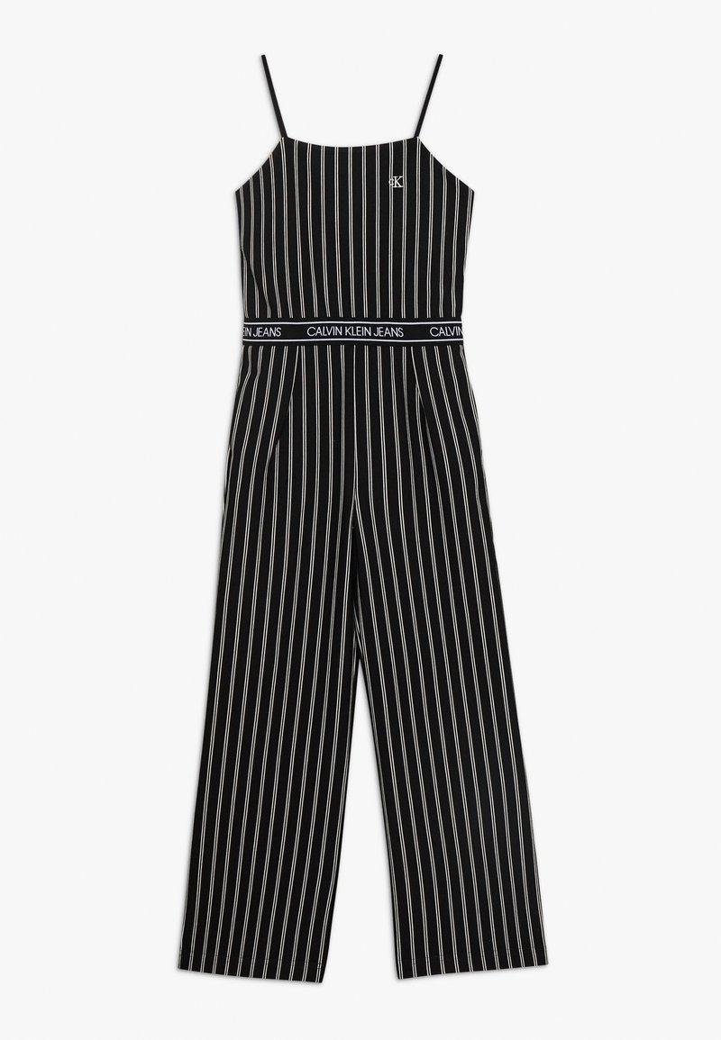 Combinaison noire sans manches à rayures verticales blanches, bretelles fines, jambes larges, avec détail de ceinture "Calvin Klein Jeans".