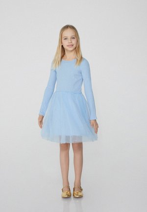 Hellblaues langärmeliges Kleid mit tailliertem Oberteil und Tüllrock. Verfügt über einen strukturierten Stoff und ein mehrlagiges Design. Kombiniert mit goldenen Schuhen.