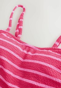 Pink og lyserød stribet smock-top med tynde stropper, fremstillet i et tekstureret stof med rynkede detaljer.