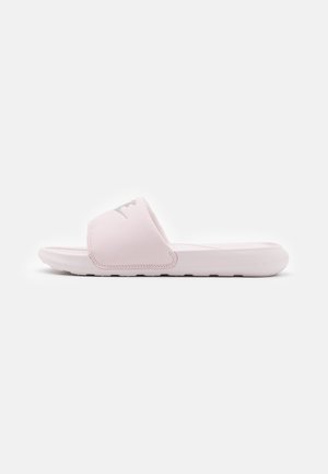 Lichtroze slipper met brede band en gevormd voetbed, van opzij getoond op een effen witte achtergrond.
