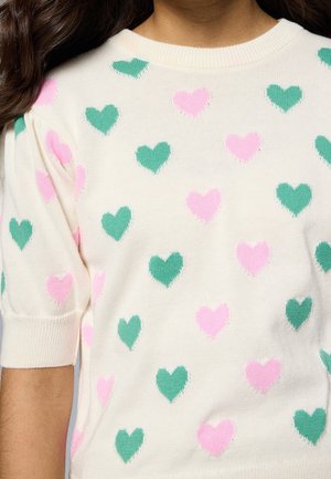Pull en maille blanc à manches courtes avec un motif de coeurs verts et roses.
